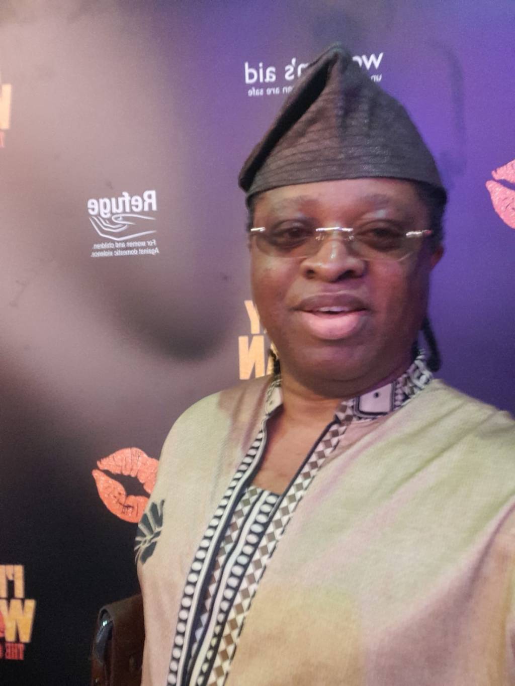 Aremuorin smiling at the media wall for I’m Every Woman: The Chaka Khan Musical starring Alexandra Burke